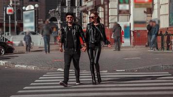 lovely young couple walks across the roady in the city photo