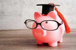 sombrero de la brecha de graduación en el dinero de los billetes en dólares estadounidenses, concepto de enseñanza de aprendizaje de la tarifa de estudio de educación. foto