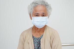 Asian elderly woman patient wearing a mask for protect Covid-19 Coronavirus. photo