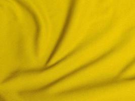 textura de tela de terciopelo amarillo utilizada como fondo. fondo de tela amarilla vacía de material textil suave y liso. hay espacio para el texto foto