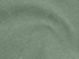 textura de tela de terciopelo de color verde oliva utilizada como fondo. fondo de tela verde oliva claro de material textil suave y liso. hay espacio para el texto. foto