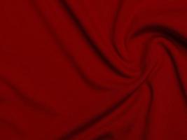 textura de tela de terciopelo rojo utilizada como fondo. fondo de tela roja vacía de material textil suave y liso. hay espacio para el texto. foto