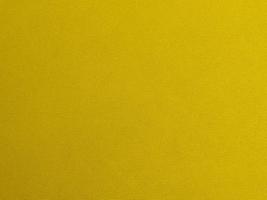 textura de tela de terciopelo amarillo utilizada como fondo. fondo de tela amarilla vacía de material textil suave y liso. hay espacio para el texto foto