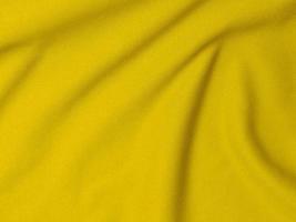 textura de tela de terciopelo amarillo utilizada como fondo. fondo de tela amarilla vacía de material textil suave y liso. hay espacio para el texto foto