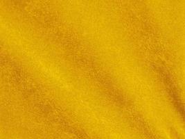 textura de tela de terciopelo amarillo utilizada como fondo. fondo de tela amarilla vacía de material textil suave y liso. hay espacio para el texto foto