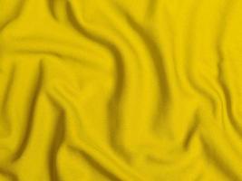 textura de tela de terciopelo amarillo utilizada como fondo. fondo de tela amarilla vacía de material textil suave y liso. hay espacio para el texto foto