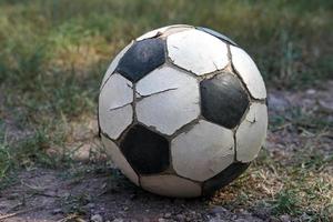 old soccer ball ,cracked leather but Thai rural students use it to play on the field during their breaks. Soft and selective focus. photo