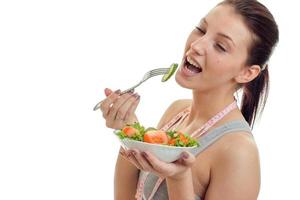 Portrait of a young cute girl eats salad closeup photo