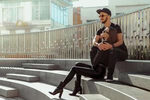 happy couple in love hugs and sits on the stairs in the city photo