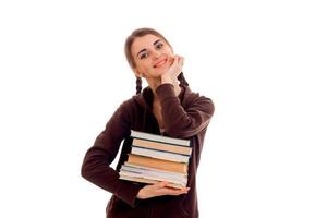 joven y bella estudiante con muchos libros en las manos posando aislada de fondo blanco en el estudio foto