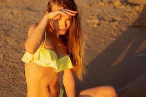 beautiful young girl in the sea at sunset photo