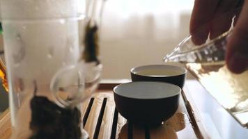 un maître de thé verse du thé chinois magique dans des bols video