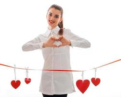 charming young brunette woman with red lips and heart in studio posing isolated on white background photo