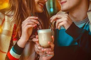 couple on a date drinking one cup of cappuccino photo