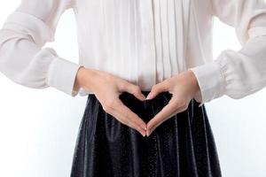 young girl keeps two hands and shows gesture sweetheart close-up photo