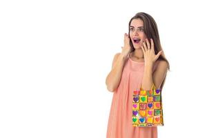happy surprised girl holding a colorful package isolated on white background photo