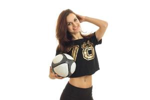 young cheerful girl in a shirt holding a soccer ball and smiling photo