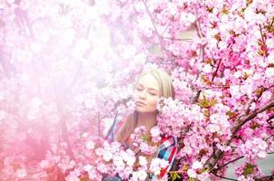 relaxed girl enjoying blooming flowers photo