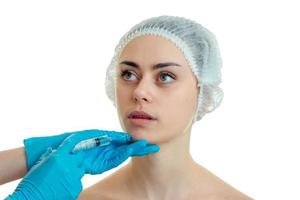 a young girl in a hat which do medical facial injections is isolated on a white background photo