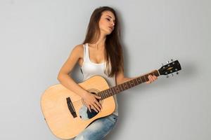 mujer con grandes pechos y guitarra en las manos foto