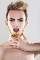 encantador modelo masculino con maquillaje y barba multicolor foto