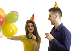 beautiful smiling girl holding balloons and stands next to fun guy photo