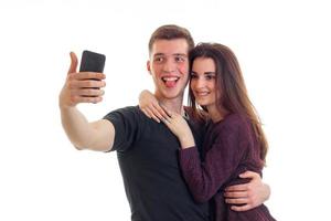 una pareja joven y hermosa hace una foto en tu teléfono y sonríe