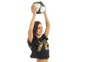 energetic young girl in black top laughs and raised the ball above her head isolated on white background photo