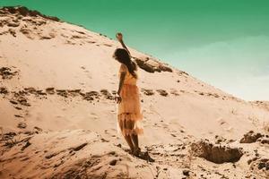 charming girl in pink dress in desert photo