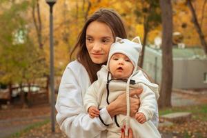 hermosa joven madre con bebé en otoño foto