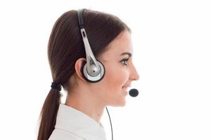 profile portrait of attractive brunette call center worker girl with headphones and microphone isolated on white background photo