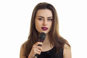 hermosa mujer vestida de negro cantando un karaoke con micrófono foto