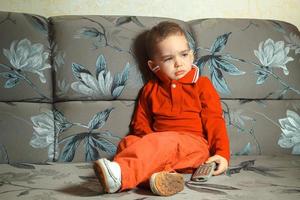 Sad young boy in red suit photo