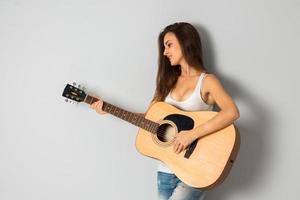 beautiful young brunette woman with guitar photo