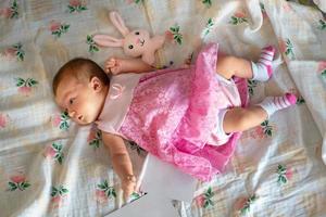 Adorable newborn girl in pink dress photo