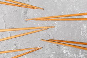 Many bamboo chopsticks on black cement stone background, top view with copy space. a lot of sushi sticks in the form of an ornament photo