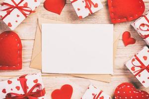 Envelope Mail with Red Heart and gift box over Orange Wooden Background. Valentine Day Card, Love or Wedding Greeting Concept photo