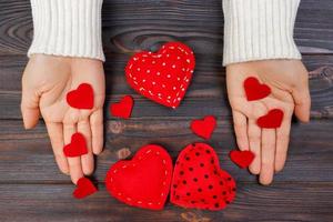 corazón rojo en la mano de la mujer sobre fondo de madera con espacio de copia. concepto para la celebración del día de san valentín o pareja de amor. concepto de amor foto