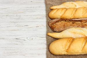 Assortment of fresh French baguettes on a wooden table photo