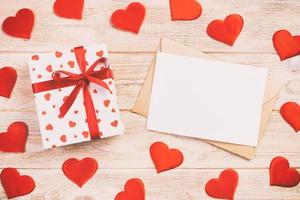 Envelope Mail with Red Heart and gift box over Orange Wooden Background. Valentine Day Card, Love or Wedding Greeting Concept photo