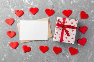 Envelope Mail with Red Heart and gift box over grey cement Background. Valentine Day Card, Love or Wedding Greeting Concept photo