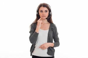 brooding young girl in t-shirt and gray jacket looks away and listening to headphones photo