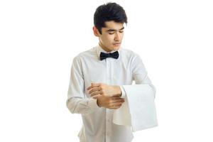 nice young waiter with black hair and shirt with a butterfly on the neck puts on hand towel photo