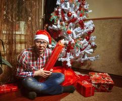 Surprised hipster with a lot of Christmas gifts photo