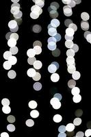 Abstract bokeh of white city lights on black background. defocused and blurred many round light photo