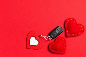 Top view of car key, wooden and textile heart on colorful background. Luxury present for Valentine's day photo