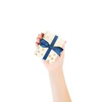 Woman hands give wrapped Christmas or other holiday handmade present in gold paper with blue ribbon. Isolated on white background, top view. thanksgiving Gift box concept photo