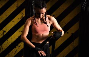 primer plano de una mujer haciendo vendas de boxeo en una jaula de combate foto