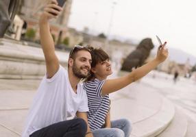 un par de turistas divirtiéndose caminando por las calles de la ciudad en vacaciones - amigos felices riéndose juntos en vacaciones - concepto de personas y vacaciones foto