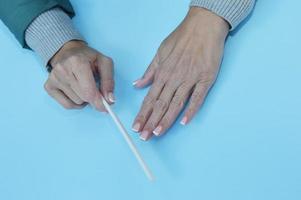 Female hands with beautiful nails and a nail file in their hands on a blue background. Manicure. photo